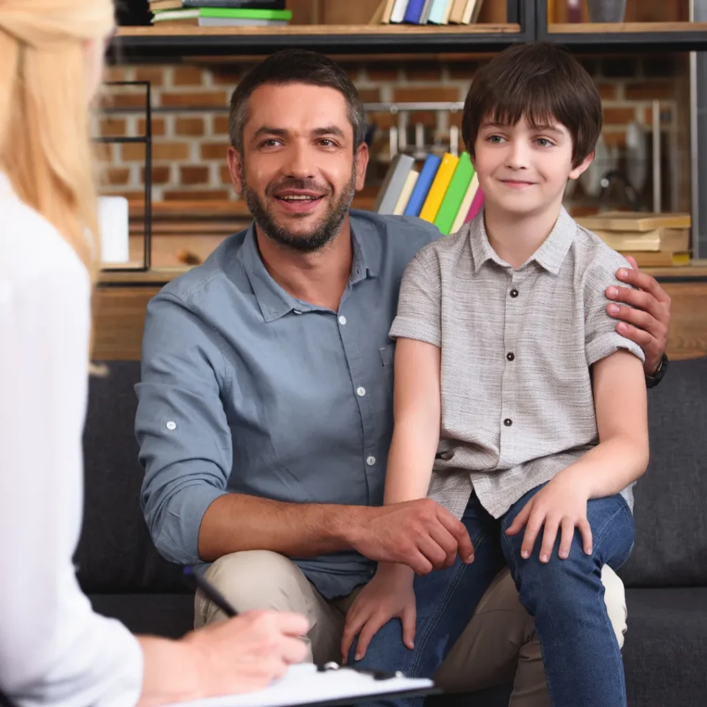 Father sitting with child in therapy session