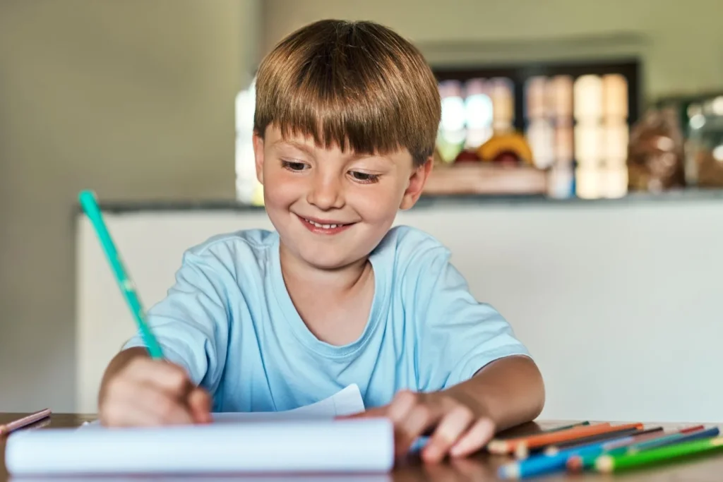 Young boy smiling and drawing